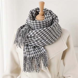 Detail of classic black and white plaid scarf with fringe on a beige coat display