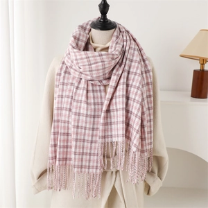 Pink and white checkered cashmere-like scarf with tassels on mannequin in cozy room