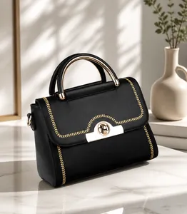 Detail der schwarzen Handtasche mit goldener Weizenstickerei und rundem Metallgriff