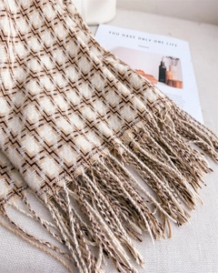 Gros plan sur l'écharpe à motif chevrons marron et beige avec détails de franges