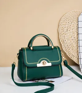 Detailansicht der dunkelgrünen PU-Ledertasche mit goldenem Drehverschluss und Ziernaht