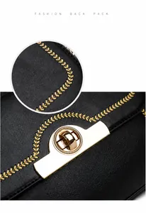 Detail der gelben Weizenstickerei und des goldenen Drehverschlusses an schwarzer Tasche