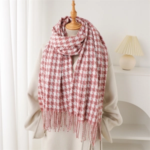 Détail d'une écharpe pied-de-poule rouge et blanc avec des franges sur un mannequin
