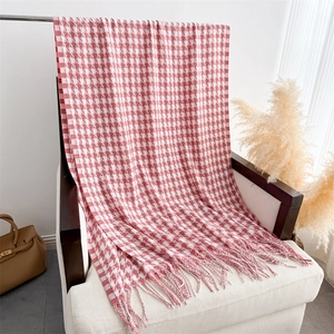 Gros plan sur la texture pied-de-poule rouge et blanc avec franges du châle