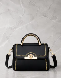 Detailansicht schwarze Lederhandtasche mit goldener V-Naht und rundem Metallverschluss