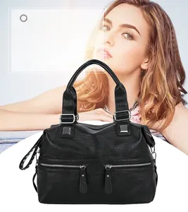 Detail of black lychee grain leather tote bag featuring dual front zipper pockets and silver hardware