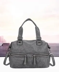 Detail of grey soft leather handbag featuring dual silver zippers and textured finish