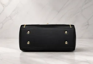 Detailansicht der Handtaschen-Unterseite mit goldenen Schutzfüßen und Ziernähten