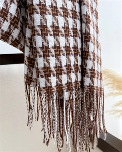 Détail de l'écharpe marron à motif pied-de-poule avec texture cachemire et pompons doux