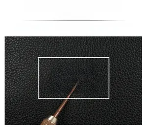 Macro shot of durable black litchi grain leather texture showing soft finish on a handbag