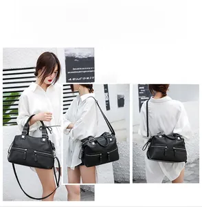 Close-up of black leather tote bag with dual front zippers and versatile shoulder strap