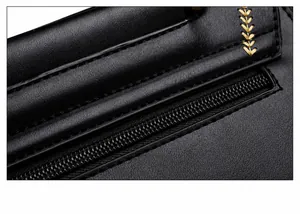 Makroansicht der schwarzen Ledertasche mit feiner Goldstickerei und detaillierten Nähten