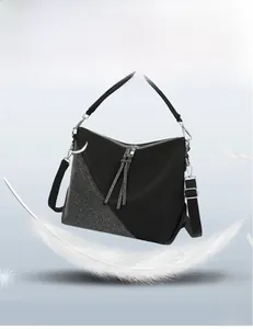 Macro detail of lightweight black PU shoulder bag with silver studs on a feather background