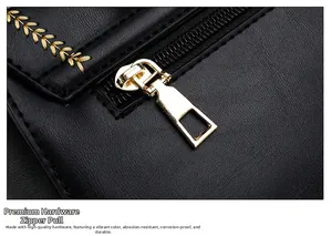 Detailansicht eines glänzenden goldenen Metallreißverschlusses an schwarzer Ledertasche