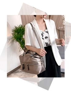 Close-up of a bronze metallic soft leather tote bag with functional zipper pockets