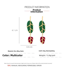 Detailed view of leaf drop earrings featuring red and green resin with gold alloy trim