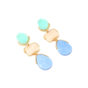 Detail of geometric resin earrings with marble texture and golden beaded frames