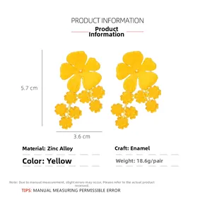 Vue détaillée de boucles d'oreilles fleur jaune avec dimensions: 5,7 cm de haut et 3,6 cm