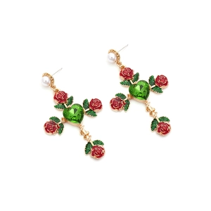Detail of gothic rose cross earrings with red enamel flowers and green heart crystal