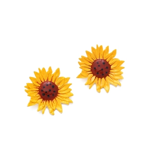 Boucles d'oreilles tournesol en émail jaune avec centre marron sur fond blanc épuré