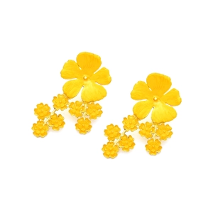 Détail macro de boucles d'oreilles fleurs en émail jaune avec texture de pétales