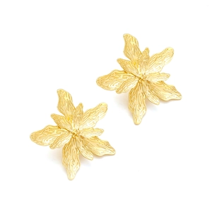 Dettaglio macro di orecchini a fiore dorati con petali testurizzati e design multistrato