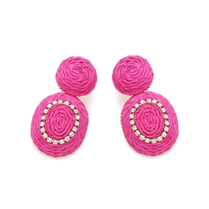 Detail of bohemian fuchsia raffia earrings with woven texture and sparkling rhinestones