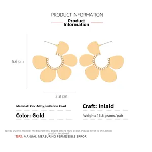 Detail view of large gold petal earrings with faux pearl inlay and size dimensions