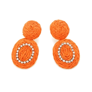 Close-up of orange raffia woven earrings with sparkling rhinestone circle detail