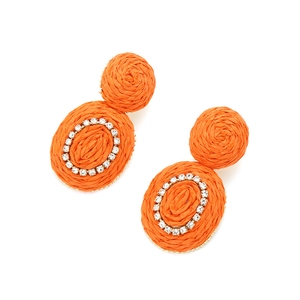 Detail view of orange hand-woven raffia earrings with sparkling rhinestone center