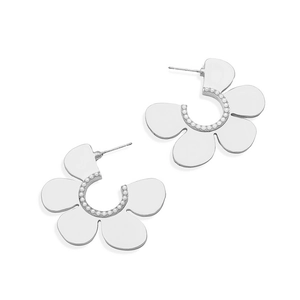 Macro detail of silver floral stud earrings featuring intricate white pearl accents