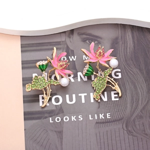 Elegant lotus flower earrings with pink enamel, green crystals, and pearls in gold finish
