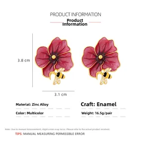 Detail view of enamel flower and bee earrings with size dimensions 3.8cm x 3.1cm