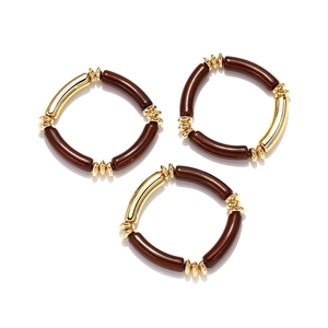 Three-piece beaded bracelet set featuring brown resin and polished gold metal tubes