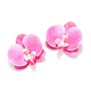 Boucles d'oreilles orchidées avec pétales dégradés roses et texture soie sur fond blanc