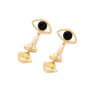 Artistic gold long drop earrings featuring surrealist eye, nose, and lip metal charms