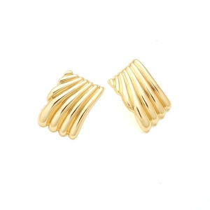Macro detail of golden pleated fan-shaped metal earrings with vertical textured stripes