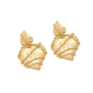 Close-up of golden heart earrings with hammered texture and chain wrap details