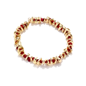 Detailed view of bohemian resin bead necklace with irregular gold metal and red stones