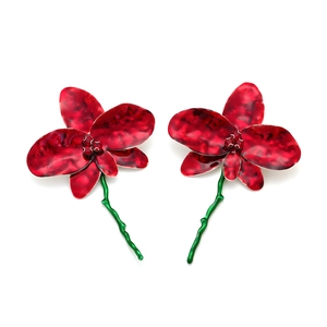 Détail de boucles d'oreilles fleurs en émail rouge avec cristaux et tiges vertes
