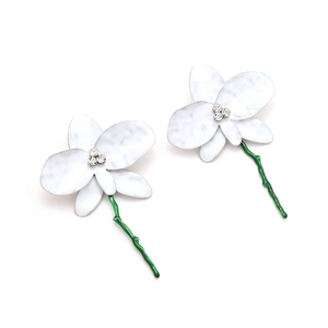 Détail de boucles d'oreilles orchidées blanches avec texture martelée et tiges vertes
