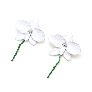 Gros plan de boucles d'oreilles orchidées en émail blanc avec tiges vertes et cristaux