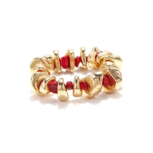 Detail of bohemian stretch bracelet with gold metal pieces and red resin stones