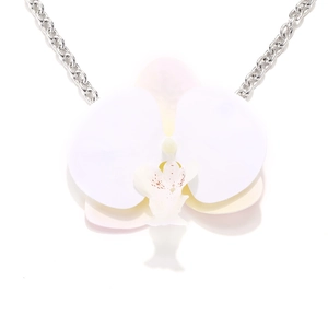 Macro view of realistic white moth orchid pendant with textured petals and silver chain