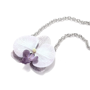 Macro shot of orchid pendant with purple gradient petals and silver chain necklace