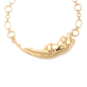 Detailed view of golden liquid human body pendant on a chunky chain necklace