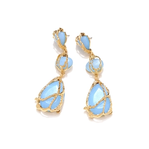 Détail des boucles d'oreilles dorées avec pierres en résine bleue en forme de goutte