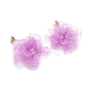 Detail of light purple organza flower earrings with delicate rhinestones on white background