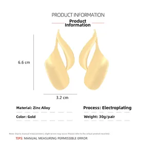 Detailed view of large gold twisted leaf earrings with 6.6cm height and 3.2cm width