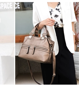 Detail of metallic brown tote bag with dual handles and silver hardware on a model